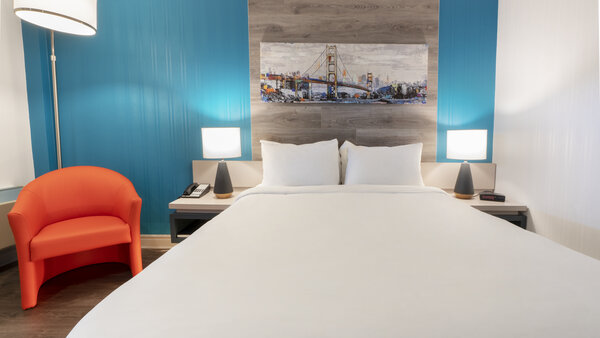 Chambre traditionnelle avec lit double, bureau et télévision, offrant une vue sur le restaurant au Québec Inn