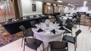 Charmante salle d'événements de l'Hôtel Québec Inn, décorée avec raffinement, tables élégantes et ambiance conviviale idéale pour réceptions et célébrations mémorables