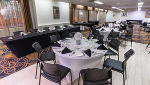Charmante salle d'événements de l'Hôtel Québec Inn, décorée avec raffinement, tables élégantes et ambiance conviviale idéale pour réceptions et célébrations mémorables