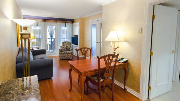 Spacious two-room suite with table and chairs, offering a breathtaking view of the Royal Palace garden