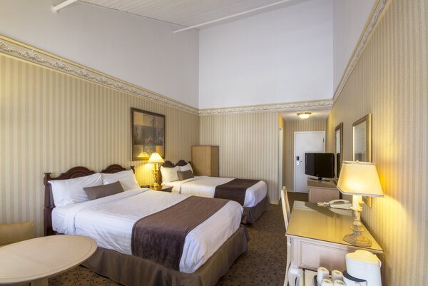 Chambre Écono-Confort avec deux lits doubles, offrant un séjour pratique et confortable à l'Hôtel Auberge