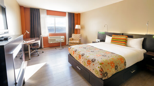 Trendy hotel room with king-size bed, multi-jet shower, fireplace, desk and TV, combining modern comfort and perfect privacy for travelers at Hotel Must