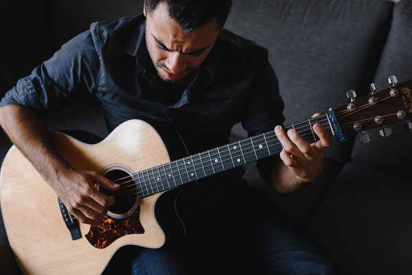 Thierry Gomez playing acoustic guitar during a musical performance at L'Hôtel Palace.