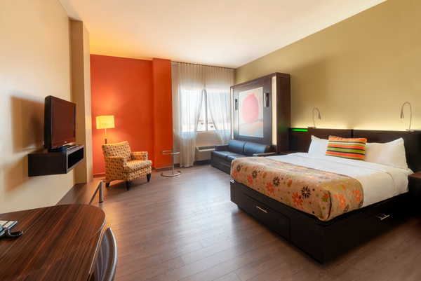 Trendy hotel room with two large beds, modern TV and warm fireplace, offering comfort and conviviality at Hotel Must.
