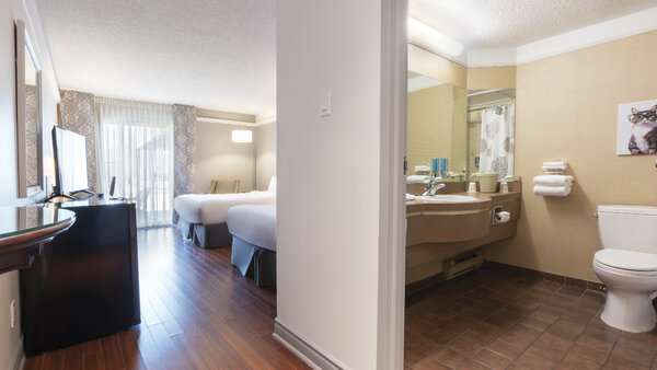 Chambre Traditionnelle avec deux lits doubles à l'Hôtel Québec Inn, avec plancher en bois, balcon et salle de bain attenante équipée